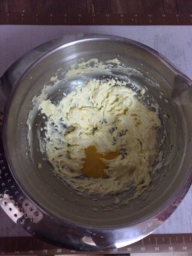 葡萄奶酥,蛋黄液打散，分多次加入黄油中。搅打均匀