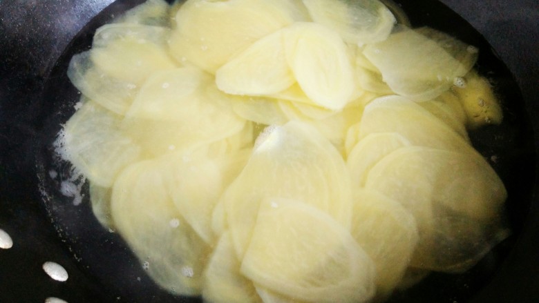 #圆土豆#香辣脆薯片,水开放入土豆片，抄一分钟，立刻捞出。