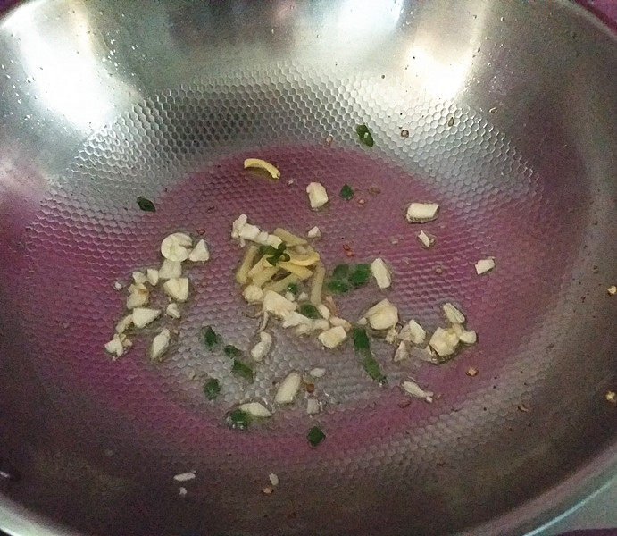 东北酸菜熘肥肠,留少许底油、依次丢入姜蒜、葱沫爆香