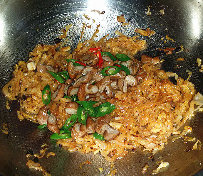 东北酸菜熘肥肠,翻炒均匀后倒入肥肠、青红椒