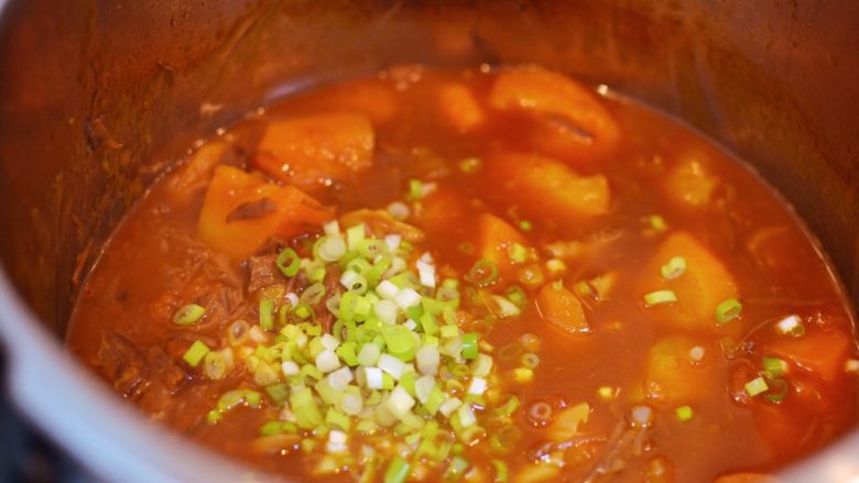 番茄胡萝卜牛腩,煮到汤汁粘稠，放入葱花搅拌均匀。（煮的时候不时搅拌一下，防止粘锅。）