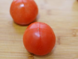 番茄胡萝卜牛腩,番茄洗净，划十字刀。