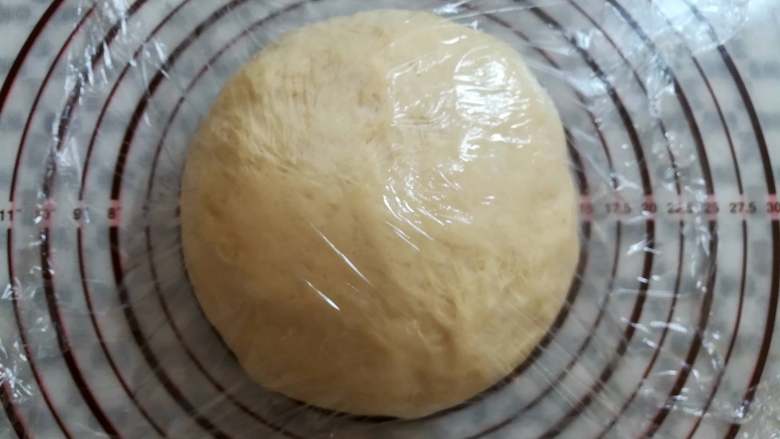 红豆面包（面包机版）,把面团取出来挤掉大的气泡，滚圆用保鲜膜盖上松弛15分钟