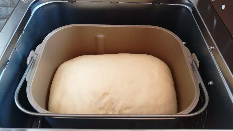 红豆面包（面包机版）,发酵完成，面团发酵到面包桶的8分满，设置面包机烘烤默认中色32分钟（如果发酵不到面包桶的8分满可以选延长发酵，轻按面包机的启动键）