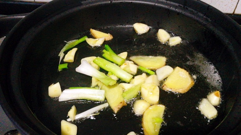 圆土豆+鸡翅塔吉锅,把锅润下油把蒜瓣和姜片，葱白段加入，煸香关火！
