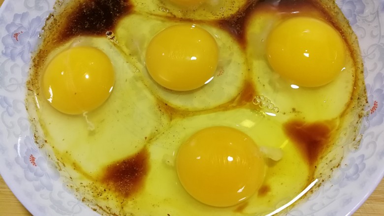 简单快手蒸蛋,底部的材料混合好后，将鸡蛋打入在盘里。