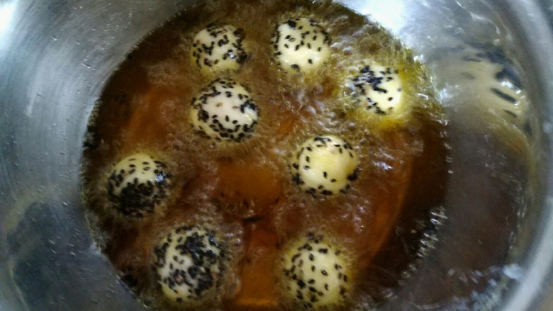 #圆土豆#黑芝麻土豆球,锅加油，油温六成热，放入土豆球炸制两面金黄即可