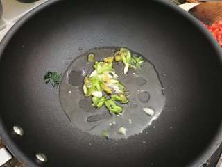 番茄肥牛卷,锅里放油加热，放入葱白和泡椒炒香。