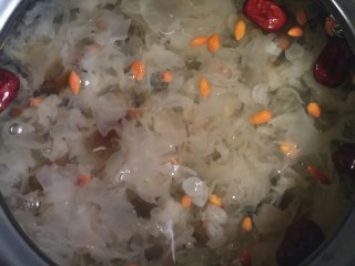 桃胶皂米雪燕银耳羹,闷10分钟后开锅，银耳羹已经煮好，枸杞和红枣使得银耳羹微微变色，汤色清亮。