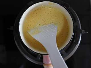 芒果牛奶雪花糕,加热的牛奶和细砂糖的锅里倒入打好的芒果泥，搅拌均匀