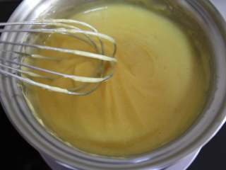 芒果牛奶雪花糕,换一个平底锅，把所有溶液倒入，小火不停搅拌至粘稠，如图