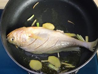 幸福的味道-红烧黄鱼,并轻轻晃动锅子，使鱼身不与锅底粘连