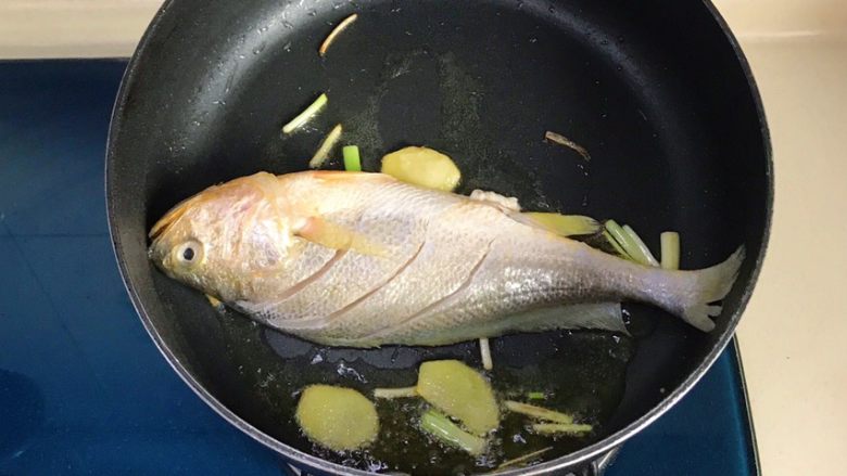 幸福的味道-红烧黄鱼,并轻轻晃动锅子，使鱼身不与锅底粘连
