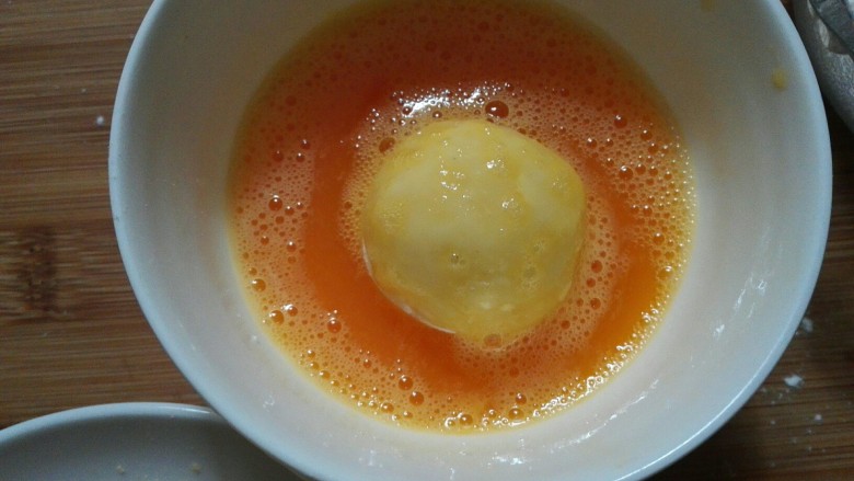 圆土豆+爆浆拉丝土豆球,放入鸡蛋液中，让土豆球均匀裹上鸡蛋液。