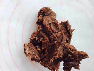网红脏脏包（开酥版）,将搅拌好的巧克力黄油，摊平在一张油纸上。