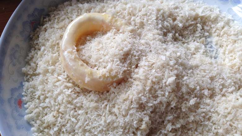 酥炸鱿鱼圈,
最后放到面包糠里用手压实，使鱿鱼圈裹满面包糠