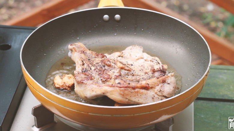 法式香草烤鸡腿,锅内倒入油，放上蒜，煎鸡腿。