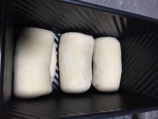 百分百中种北海道醇奶吐司,三个分别卷起，排列在吐司盒内