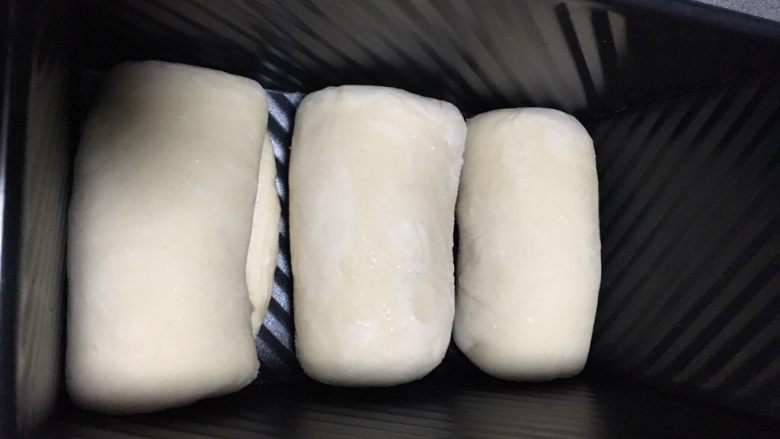 百分百中种北海道醇奶吐司,三个分别卷起，排列在吐司盒内