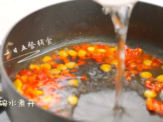 鸡蛋豆腐鲜虾羹,加入玉米、红椒翻炒半分钟，加半碗水煮开。