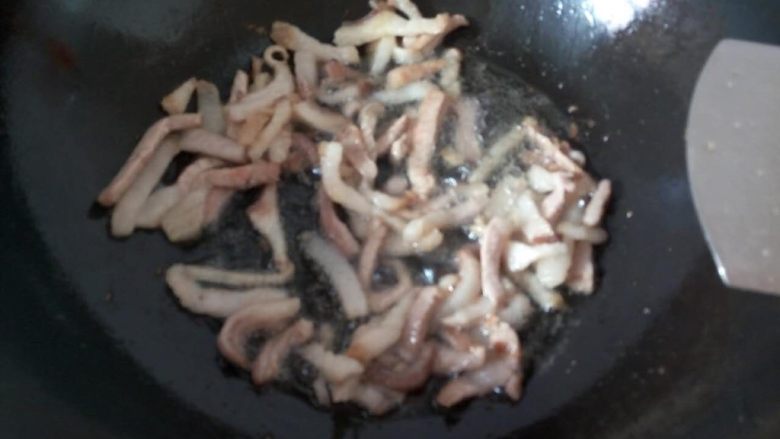 圆土豆+蒜薹炒洋芋擦擦,铁锅倒入适量食用油（或者猪油），放入五花肉丝炒出大量油。