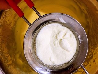 蛋黄溶豆豆,加入奶粉，用筛子过滤一下。