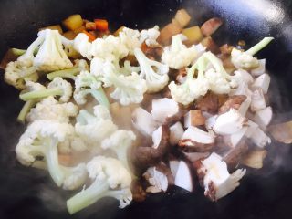 #圆土豆# 酱烧土豆杂蔬,放入菜花和香菇丁，煸炒均匀，把菜花烧至七成熟。