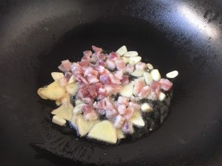 #圆土豆# 酱烧土豆杂蔬,放入五花肉丁，翻炒至肉丁发白。