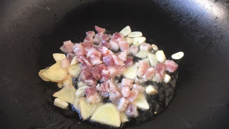 #圆土豆# 酱烧土豆杂蔬,放入五花肉丁，翻炒至肉丁发白。