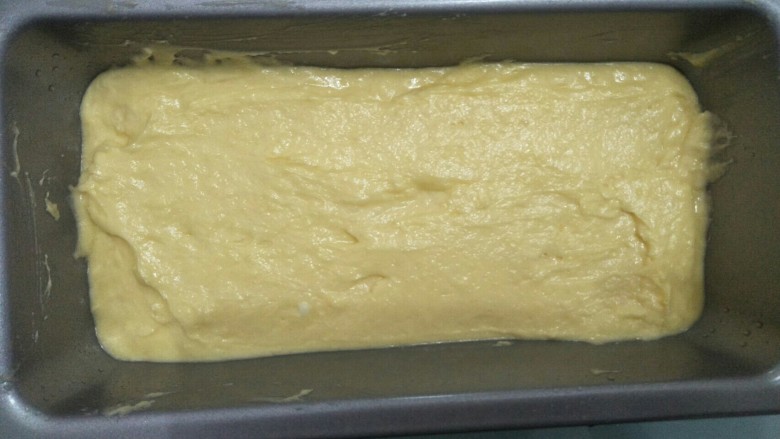 百香果磅蛋糕,将面糊放入不粘模具中，振平并用抹刀将表面刮平。模具可以先涂一层薄油或者垫油纸便于脱模。