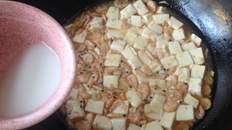 磷虾烧豆腐,再次将水淀粉搅拌均匀慢慢倒入锅中，并用锅铲轻推豆腐，使汤汁变得略微粘稠
