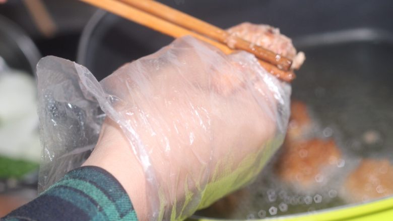 老北京小吃之“干炸小丸子”,第一遍炸丸子180度高温，目的是为了给丸子定型。虎口挤出的小丸子用筷子迅速从根部抹下去，这个动作一定要快做出来的形状才好看。