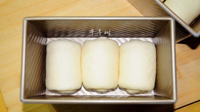 中种法奶香吐司面包,吐司模具用黄油抹上薄薄的一层，便于烤后脱模。将卷好的吐司面团放到模具中。把吐司模具放入带有发酵功能的烤箱中进行二次发酵，可以在有发酵功能的烤箱中放一盘热水，营造一个温度35-40度左右，湿度70-80%的发酵环境。发酵到8分满，用手指轻轻的压一下会感受到微弱的弹性，并且不会沾手。