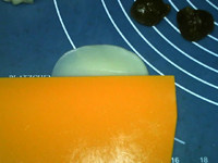 菠萝冰皮月饼,取一块剂子，用切面刀抹成中间厚边缘薄的圆片