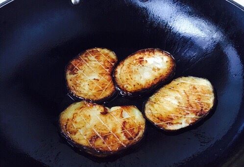 #圆土豆# 土豆烧茄子,起锅锅热放入50g的油，中火，放入茄子片，每片每面煎制约2分钟左右，把茄子的两面都煎至金黄色。煎好的茄子，沥一下油。