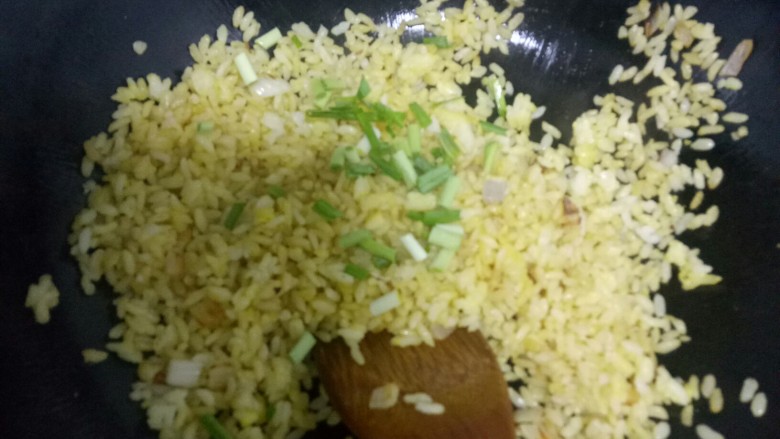 黄金炒米,根据个人口味放入适量盐，搅拌均匀，撒上蒜苗碎，关火。