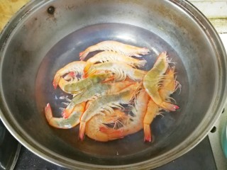 中西结合的黄油香煎孜然大虾,烧一点水，水开后把大虾放进去焯一下，看到虾壳变红，一分钟即可