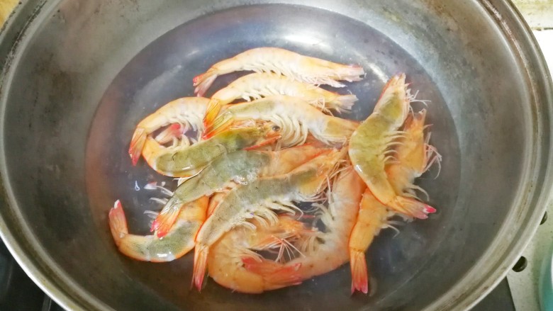 中西结合的黄油香煎孜然大虾,烧一点水，水开后把大虾放进去焯一下，看到虾壳变红，一分钟即可