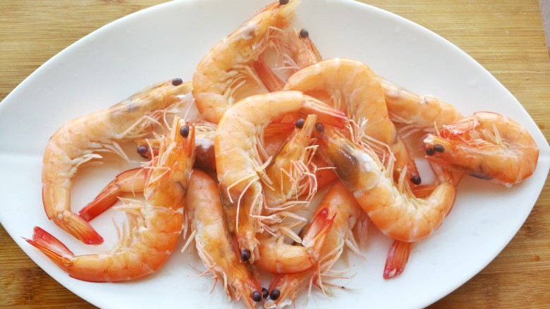 中西结合的黄油香煎孜然大虾,焯好的大虾，捞出来放在盘子里，