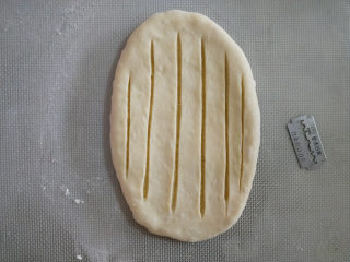 椰蓉小吐司,用锋利的刀片切开表面，只切到馅，不要切透了。
