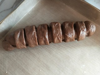 巧克力流心面包卷,自上而下卷起，捏紧收口位置，放入烤盘。