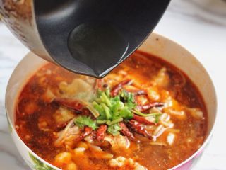 麻辣水煮鱼,将鱼片铺在碗里，表面放上刚才煸好的干红辣椒和花椒，撒上花椒粉、辣椒粉、香菜末。锅中加些许油加至八九成热，淋在鱼片上就可以了。