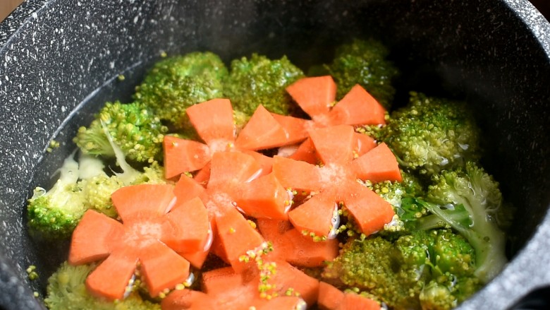 卡通肥牛饭,锅中水开下入西兰花跟胡萝卜，煮熟后捞出