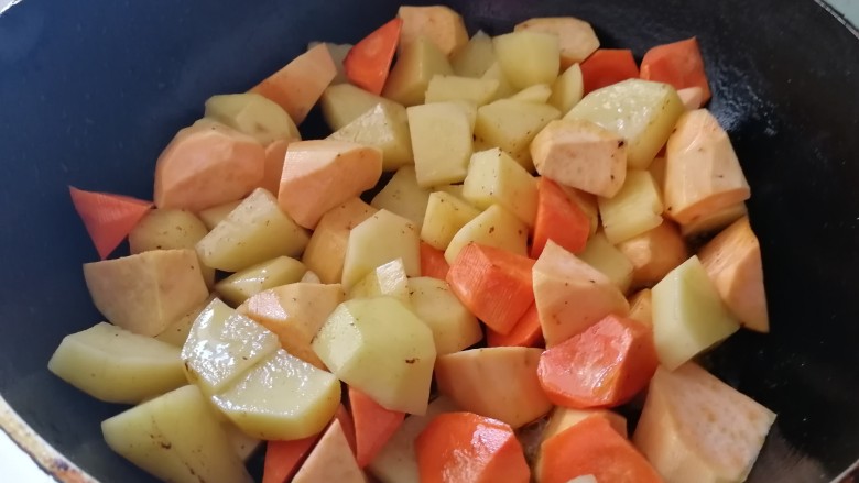 翅中香焖干锅地瓜土豆,盛出翅中，土豆地瓜胡萝卜一起放入锅里（锅里有煎翅中的油）