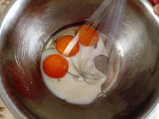 棉花糖蛋糕派,蛋黄盆里加入牛奶和玉米油用手动打蛋器打散，