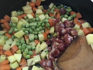 香肠土豆🥔焖饭,加入香肠和青豆翻炒、炒至出香味
