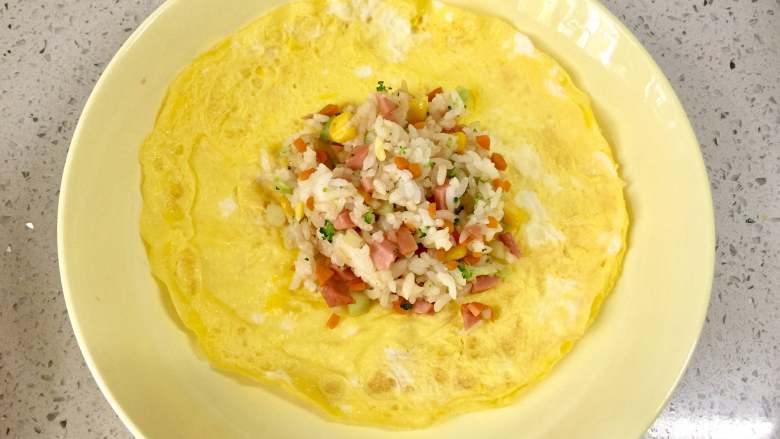 百变鸡蛋+福袋饭,把适量的炒饭舀入蛋皮中间，边缘捏褶把饭包起，收口用焯过的玉米叶撕成的细条扎起来。