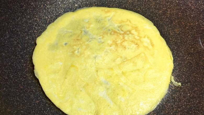 百变鸡蛋+福袋饭, 锅里倒入适量鸡蛋液，摊成圆形的蛋皮，两面煎熟，用小火慢煎，避免过焦，蛋皮不要太大，直径约16厘米。也不要太薄，避免包饭的时候破裂。煎三张。