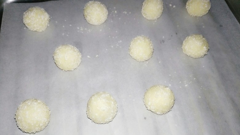 蛋白椰丝球,烤盘垫油纸
将椰丝球均匀的摆上
烤箱150预热5分钟