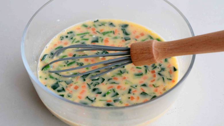 菠菜胡萝卜厚蛋烧,搅拌好的蛋糊放入冷却的胡萝卜丁、切碎的菠菜，拌均匀；
